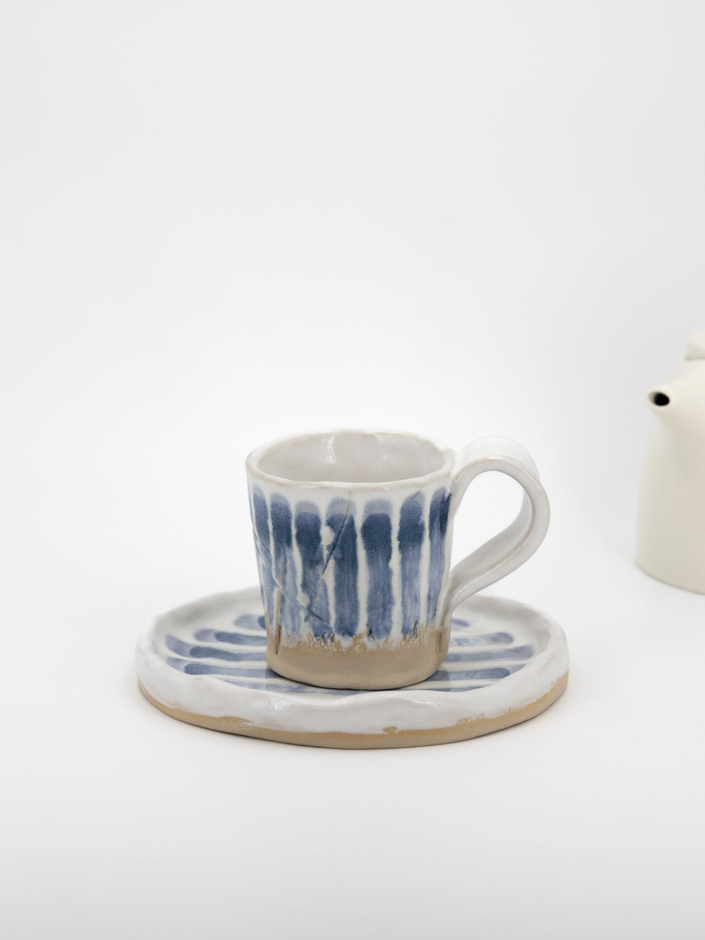 Tasse und Untertasse mit blauen Streifen